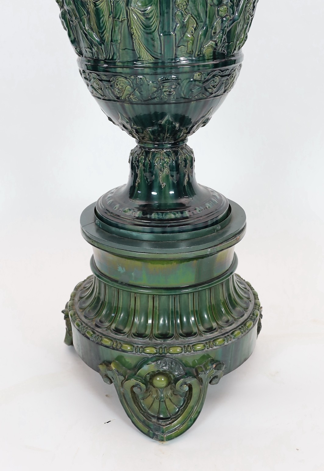 A massive Continental majolica green glazed campana vase and associated stand, late 19th century, total height 153cm, small repairs